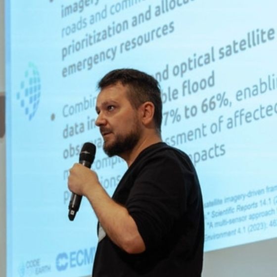 Ioannis Kalfas presenting satellite-based flood mapping work on stage